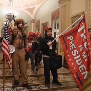 Des supporters de Donald Trump, dont un membre du groupe Qanon, ont fait irruption dans le Capitole. [AFP - Saul Loeb]