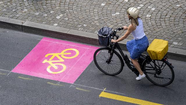 Une cycliste emprunte une toute nouvelle piste cyclable à Genève, en juin 2020. [Keystone - Martial Trezzini]