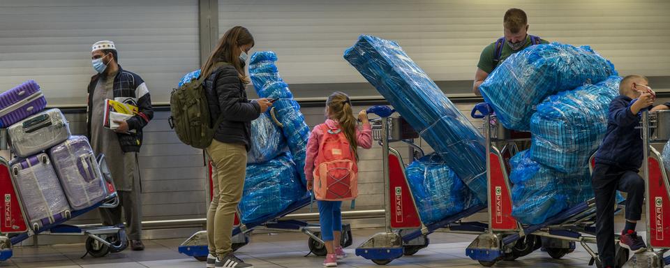 Des voyageurs attendent de pouvoir embarquer à Johannesburg alors que les pays interdisent progressivement les vols en provenance d'Afrique du Sud. [Ap Photo/Keystone - Jerome Delay]