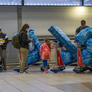 Des voyageurs attendent de pouvoir embarquer à Johannesburg alors que les pays interdisent progressivement les vols en provenance d'Afrique du Sud. [Ap Photo/Keystone - Jerome Delay]