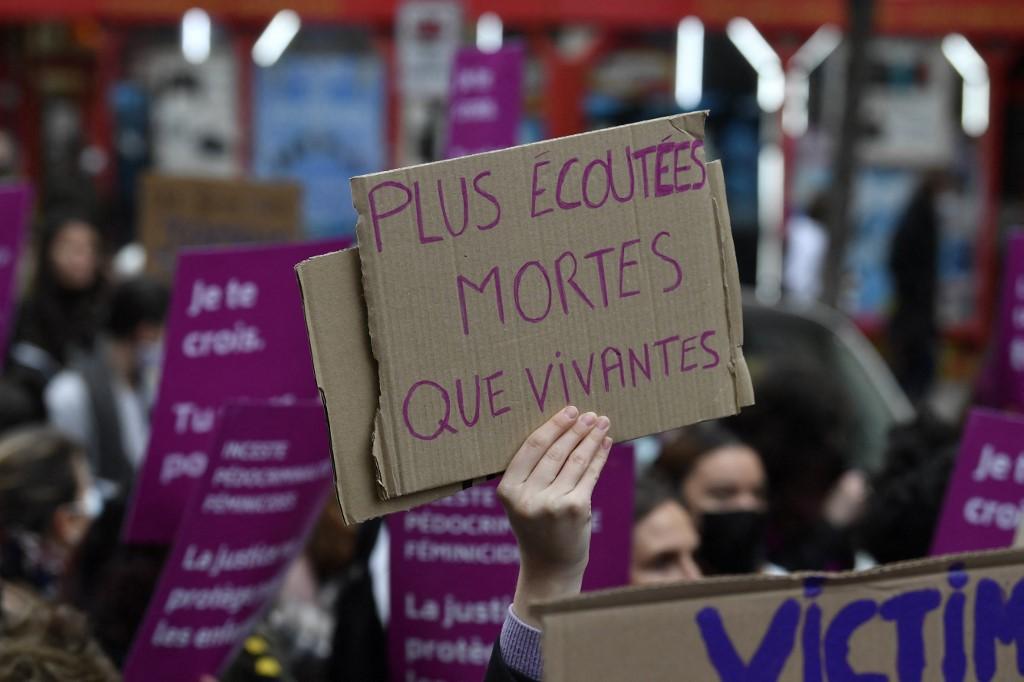 Une manifestante tient une pancarte sur laquelle on peut lire "Plus écoutées mortes que vivantes", lors d'une manifestation contre les violences sexistes et sexuelles à Paris, le 20 novembre 2021. [AFP - Alain Jocard]