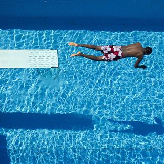 Nageur plongeant dans le bassin de la piscine de Bellerive. [Keystone - Jean-Christophe Bott]