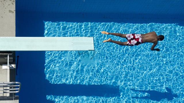 Nageur plongeant dans le bassin de la piscine de Bellerive. [Keystone - Jean-Christophe Bott]