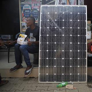 Un panneau solaire dans une rue de Lagos, au Nigeria. [Keystone - EPA/AKINTUNDE AKINLEYE]