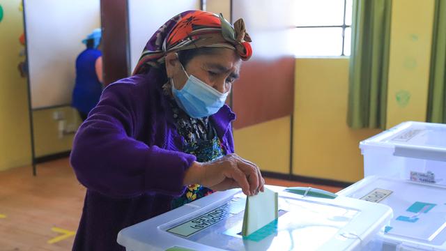 Une femme Mapuche dépose son bulletin de vote dans un bureau de vote lors des élections générales chiliennes à Temuco, le 21 novembre 2021. [AFP - Mario Quilodran]