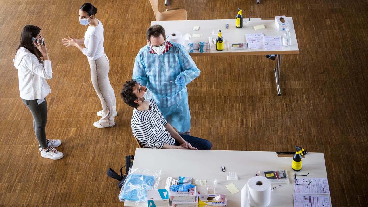 Des personnes font un test Covid dans un centre de dépistage au Mont-sur-Lausanne. [Keystone - Jean-Christophe Bott]