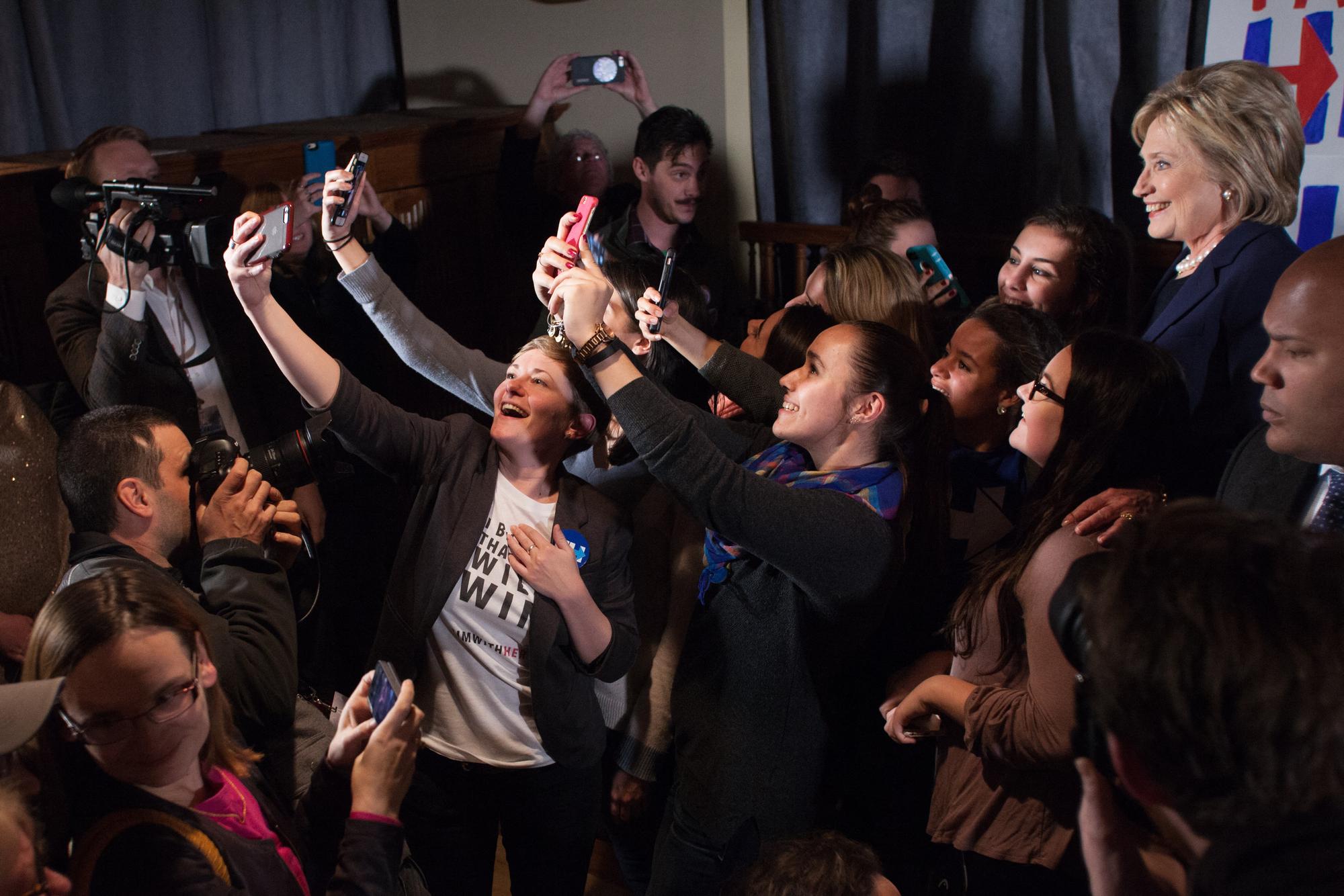 Hillary Clinton, candidate démocrate à la présidentielle américaine, prend la pose pour des selfies avec des supporters et supportrices dans le New Hampshire en 2016. [Getty Images/AFP - Matthew Cavanaugh]