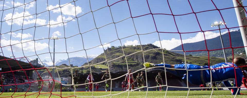 L'attaquant valaisan Lubomir Tupta, marque le but du 1:1 au gardien du FC Thun Andreas Hirzel lors du match retour du barrage entre le club de fooball de super league FC Sion et le club de challenge league FC Thun le dimanche 30 mai 2021 au stade de Tourbillon a Sion. [Keystone - Jean-Christophe Bott]