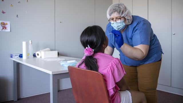 Une enfant se soumettant à un dépistage du Covid-19. [Keystone - Jean-Christophe Bott]