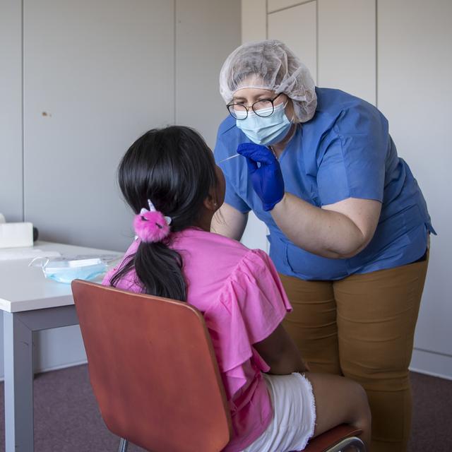 Une enfant se soumettant à un dépistage du Covid-19. [Keystone - Jean-Christophe Bott]