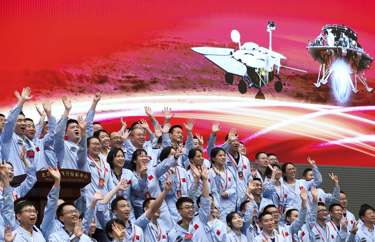 Les membres du Centre de contrôle aérospatial de Pékin célèbrent l'arrivée sur Mars de Tianwen-1. [Keystone - Jin Liwang/Xinhua]