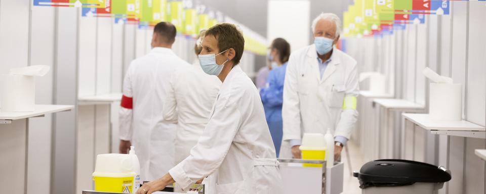 Des membres de l'équipe médicale dans le centre de vaccination de Palexpo à Genève. [Keystone - Salvatore Di Nolfi]