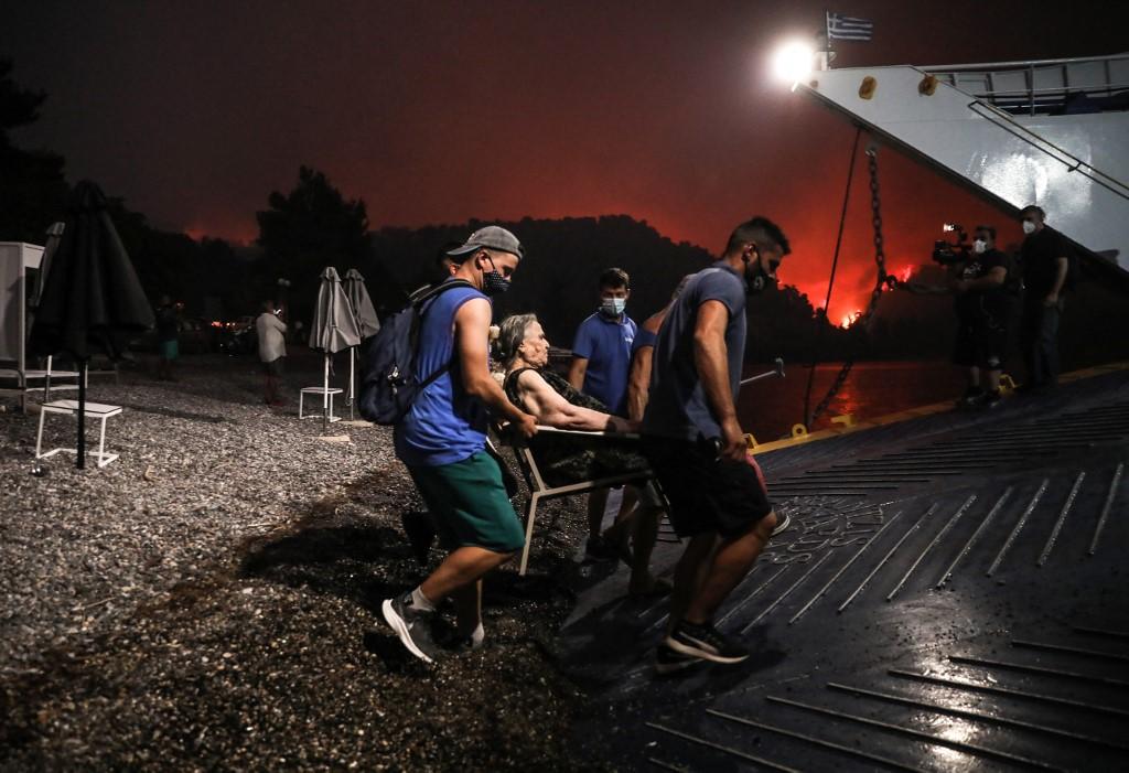 Des habitants de Limni évacués par bateau. [AFP - Sotiris Dimitropoulos]