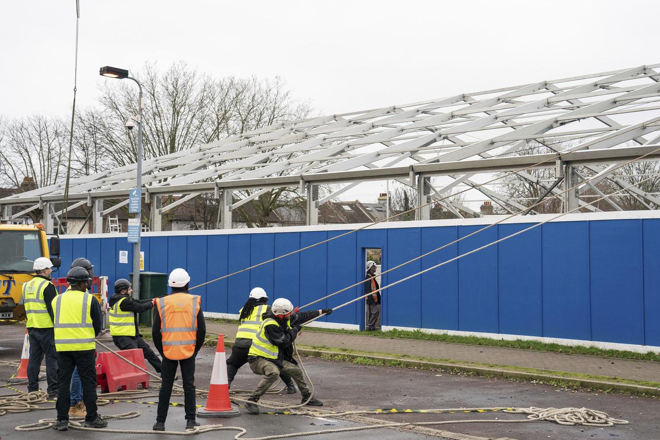 Des ouvriers construisent un "centre de crise" à l'hôpital St George, dans le sud-ouest de Londres, le 30 décembre 2021. [Keystone - Dominic Lipinski/PA via AP]