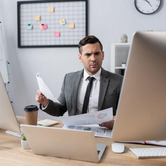 Un homme consulte des données, assis à son bureau. [Depositphotos - HayDmitriy]