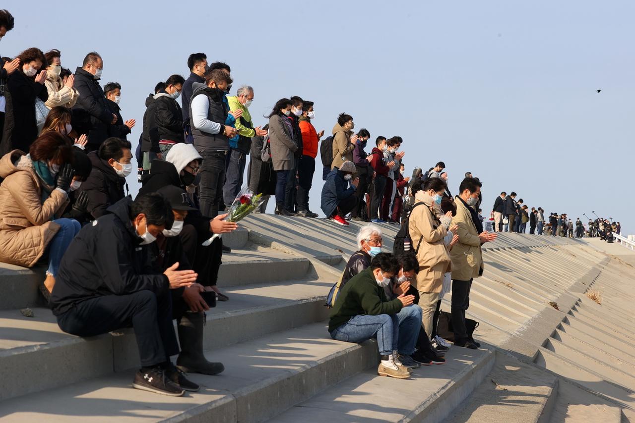 Des prières silencieuses sur le bord de mer de Sendai, en mémoire des victimes du 11 mars 2011. Préfecture de Miyagi, Japon, le 11 mars 2021. [Keystone/epa - Jiji Press]