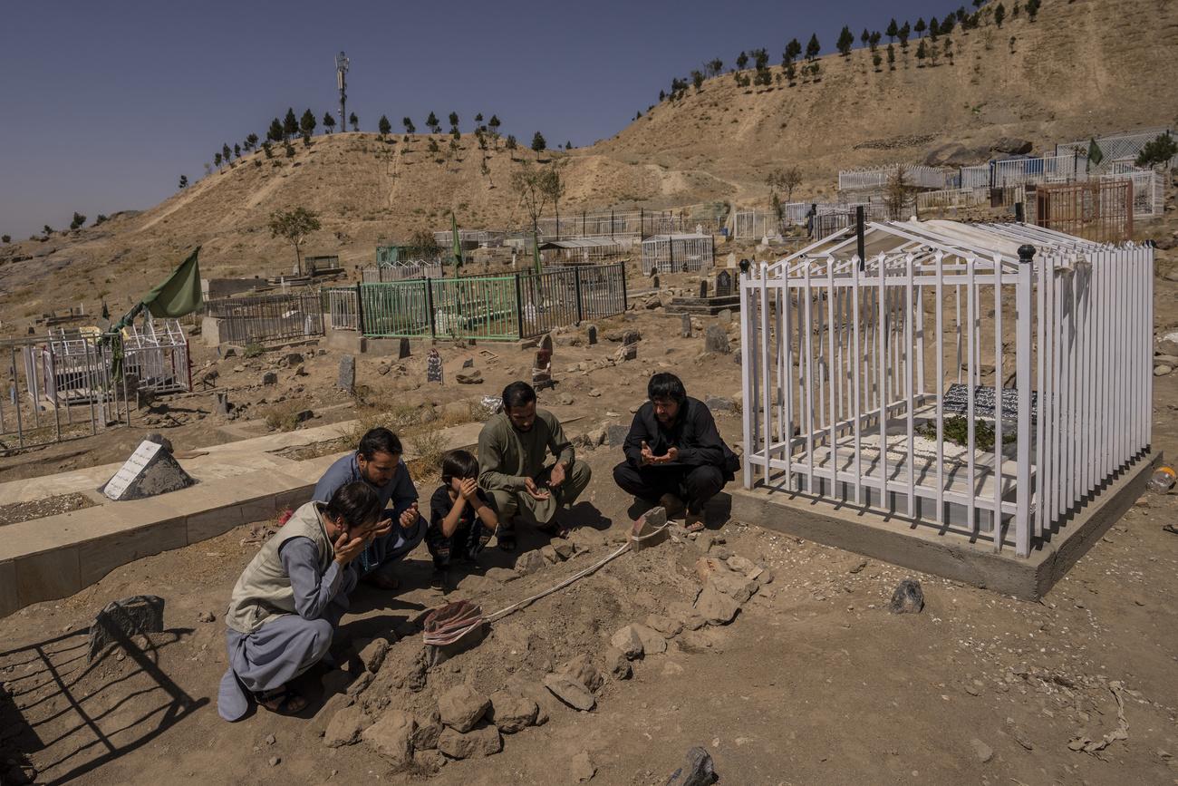 La famille Ahmadi prie au cimetière à côté des tombes des membres de sa famille tués par une frappe de drone américaine, à Kaboul. Afghanistan, le 13 septembre 2021. [Keystone/AP photo - Bernat Armangue]