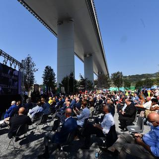 Une cérémonie en hommage aux victimes sous le nouveau pont traversant Gênes. [Keystone - EPA/Luca Zennaro]