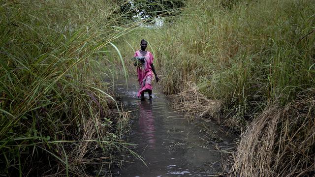 Une femme marche sur un chemin inondé dans le village de Dijeri, en périphérie de Djouba. Soudan du Sud, le 1er octobre 2021. [Keystone/AP photo - Adrienne Surprenant]