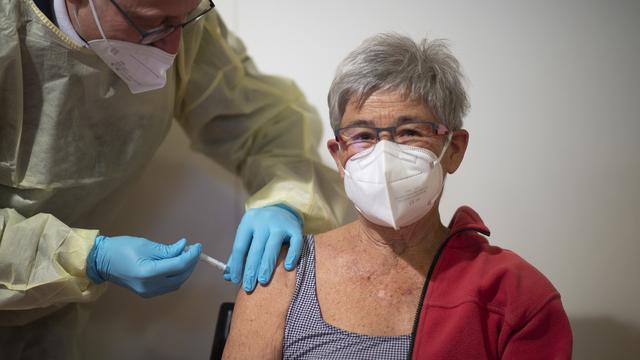 Une femme vaccinée dans les Grisons. [Keystone - Gian Ehrenzeller]