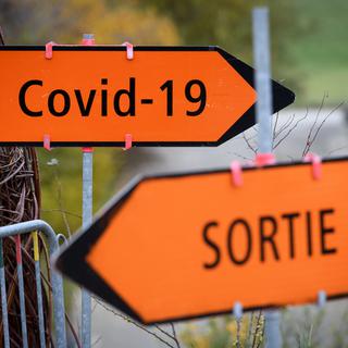 Des panneaux Tri Covid-19 et Sortie indiquent le chemin du centre de dépistage du Covid-19 sur le site de NOMAD (Neuchâtel Organise le Maintien a Domicile) lors d'un point presse sur l'ouverture de son 5ème centre de dépistage du Covid-19 lors de la 2ème vague de la pandémie de Coronavirus (Covid-19) ce mardi 3 novembre 2020 au Mycorama a Cernier dans le canton de Neuchâtel. [Keystone - Laurent Gillieron]