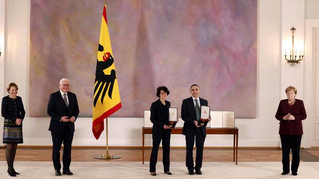 Özlem Türeci et Ugur Sahin (au centre), fondatrice et fondateur du laboratoire BioNTech, ont reçu la Grand-Croix du Mérite avec étoile, l'une des principales distinctions allemandes. Berlin, le 19 mars 2021. [Keystone via AP - Odd Andersen/Pool Photo]