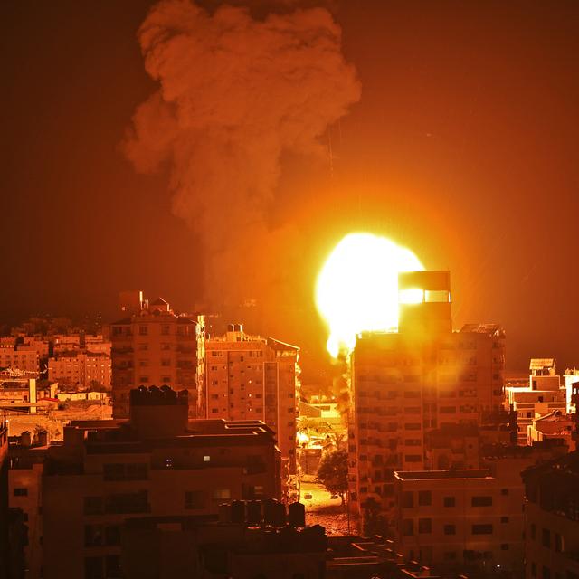 Fumée et boule de feu s'élèvent des points d'impact de roquettes lancées par Israël sur la ville de Gaza, pendant la nuit du 16 au 17 mai 2021. [AFP - Mahmud Hams]