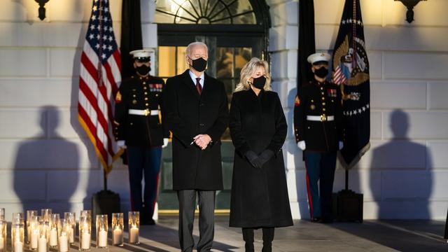 Joe et Jill Biden se sont recueillis devant la Maison Blanche, entourés de bougies. [Keystone - EPA/Jim Lo Scalzo]