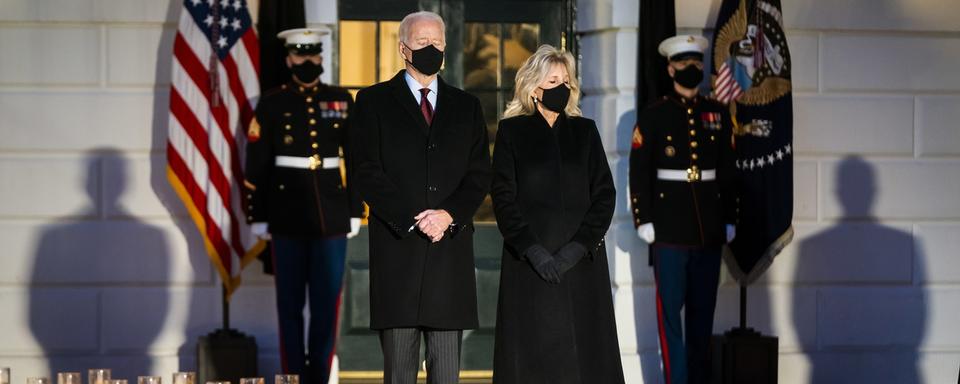 Joe et Jill Biden se sont recueillis devant la Maison Blanche, entourés de bougies. [Keystone - EPA/Jim Lo Scalzo]