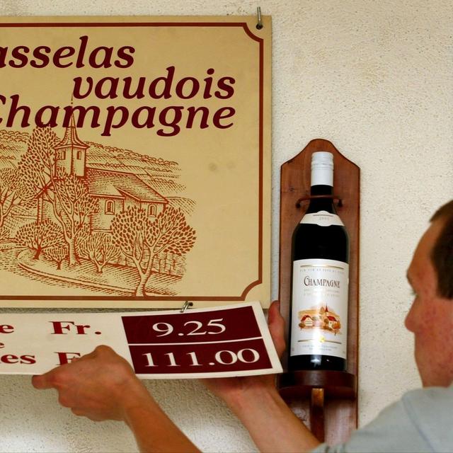 Un caviste prépare les panneaux de vente du Vin vaudois de Champagne en 2002. [Keystone - Fabrice Coffrini]