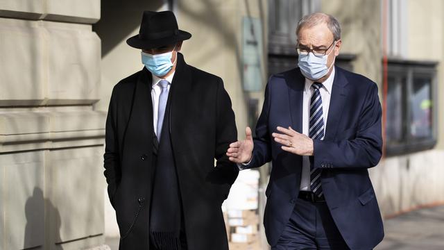 Le président de la Confédération Guy Parmelin (à droite) et le conseiller fédéral Alain Berset (à gauche), en route pour le Palais fédéral. Berne, le 24 février 2021. [Keystone - Peter Klaunzer]