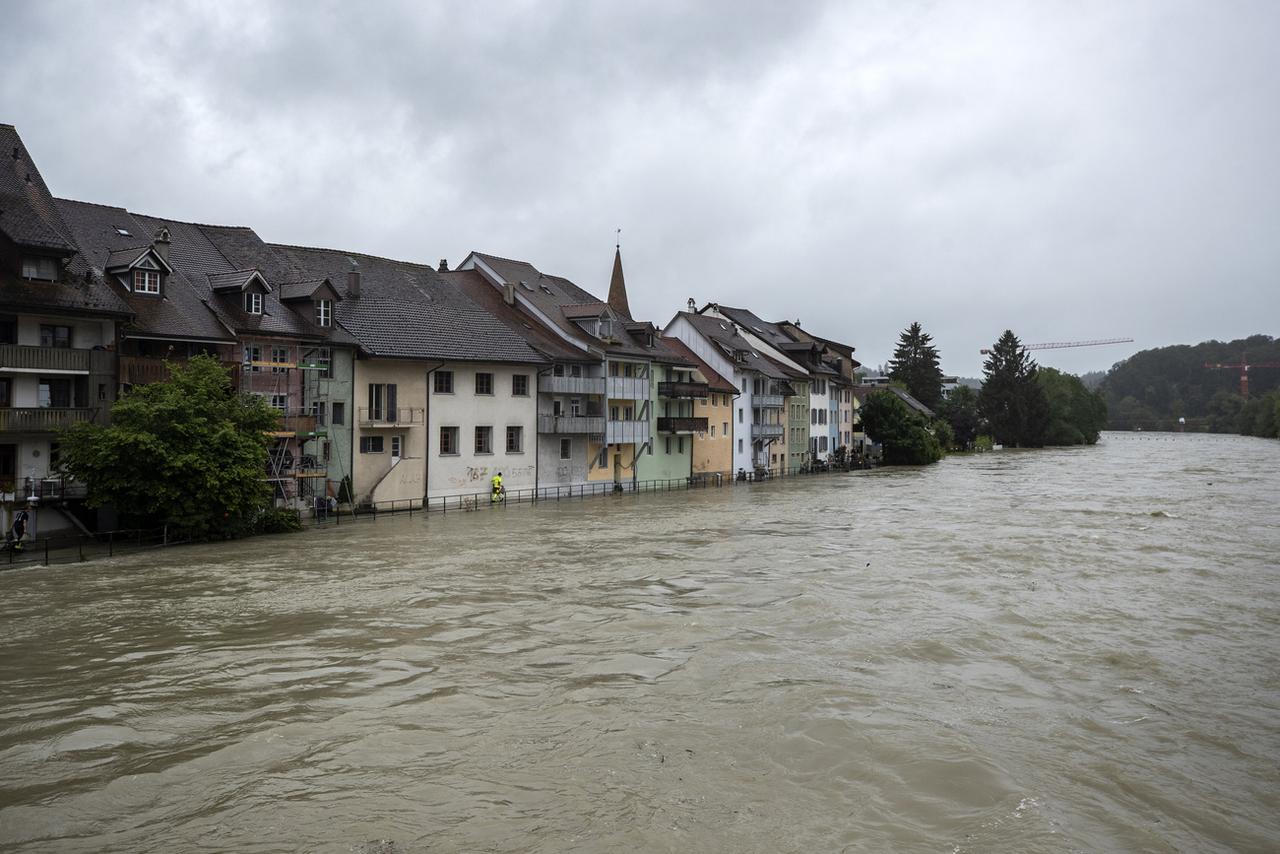 Protection civile et pompiers déposent des sacs de sable devant des maisons à Mellingen, sur la Reuss, qui est en crue en raison des fortes pluies. Le 15 juillet 2021. [Keystone - Alexandra Wey]