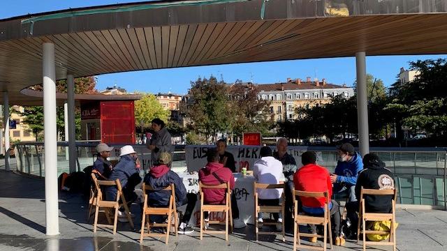 Une photo de la réunion avec les migrants (de dos) des bénévoles du réseau d’aide sur la Place de la mairie à Irun. [RTS - Valérie Demon]