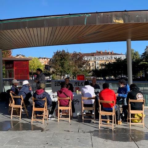 Une photo de la réunion avec les migrants (de dos) des bénévoles du réseau d’aide sur la Place de la mairie à Irun. [RTS - Valérie Demon]