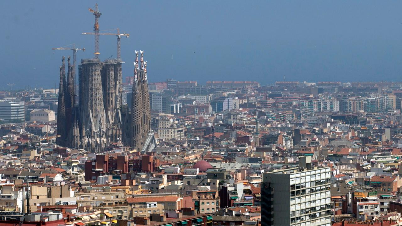 Vue générale de la ville de Barcelone avec l'église Sagrada Familia (L), à Barcelone, en Espagne, le 01 juillet 2019. Le gouvernement régional de Catalogne a déclaré un épisode de pollution atmosphérique dû aux particules (PM10) et une alerte précoce de pollution atmosphérique au dioxyde d'azote. [EPA/Keystone - Quique Garcia]