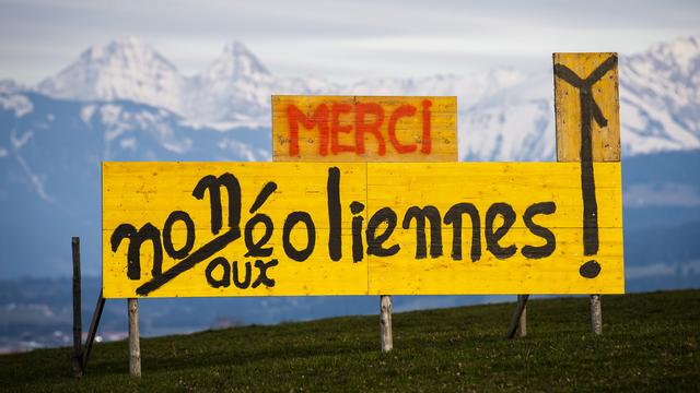 Un panneau "Non aux eoliennes" est visible dans un champ contre le projet de parc eolien "Monts de Vuisternens" dans le canton de Fribourg le mercredi 10 mars 2021 a Sommentier. Le gouvernement fribourgeois prevoit un concept eolien a sept parcs dans son plan directeur cantonal, afin de renforcer l'energie eolienne. (KEYSTONE/Jean-Christophe Bott) [KEYSTONE - JEAN-CHRISTOPHE BOTT]