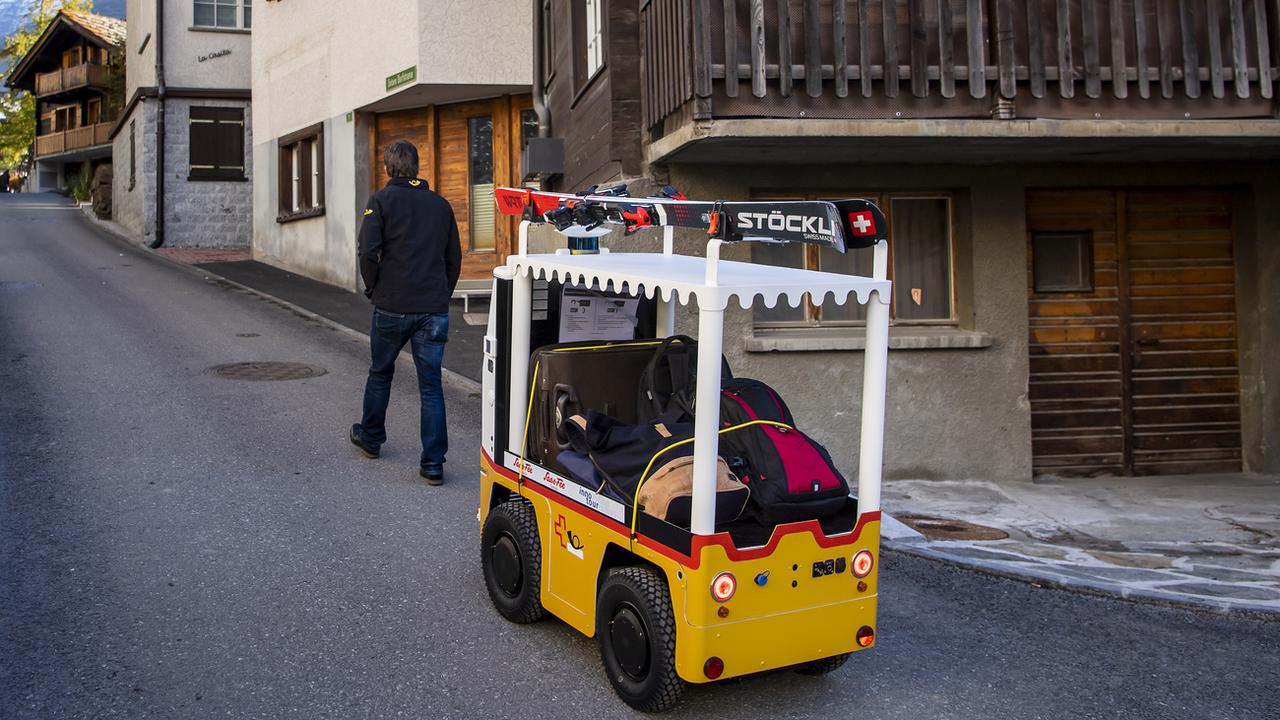Vendredi 22 octobre: "Robi" le robot à bagages circule à Saas Fee (VS) après avoir été présenté à la presse. Il doit permettre de faciliter le déplacement des touristes avec leurs bagages dans la station. [Keystone - Jean-Christophe Bott]