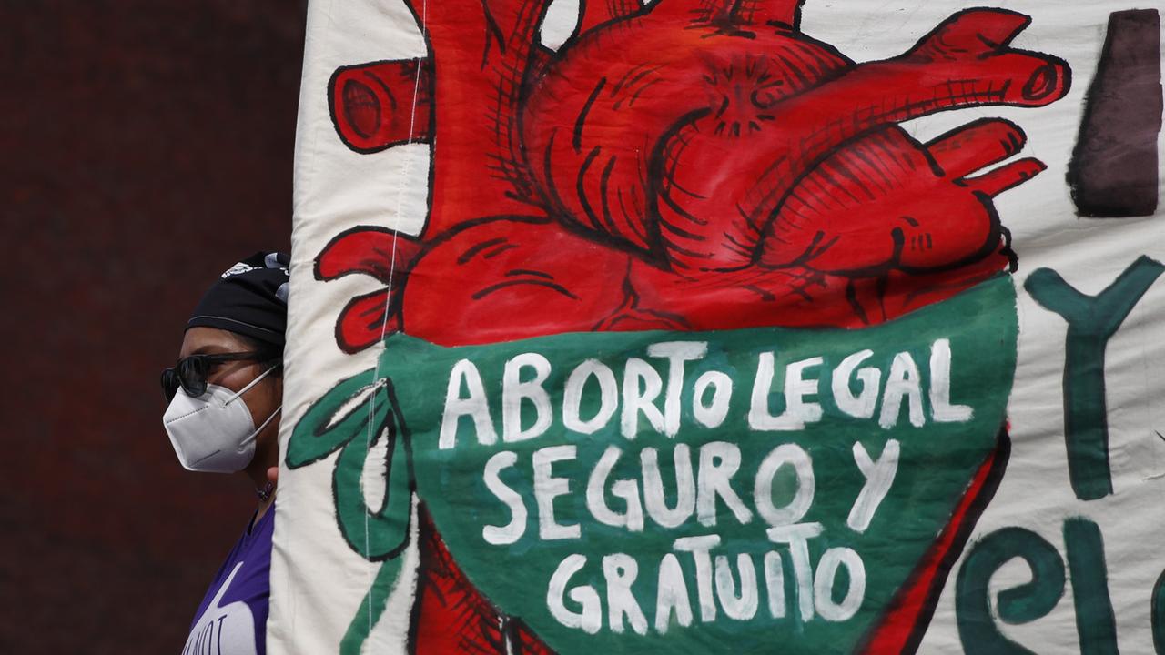 Une femme tient une bannière où il est écrit en espagnol "Avortement légal, sûr et gratuit, légalisez et décriminalisez l'avortement maintenant". [Keystone/AP photo - Rebecca Blackwell, File]
