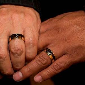 Les mains d'un couple d'hommes avec leur bague de mariage.