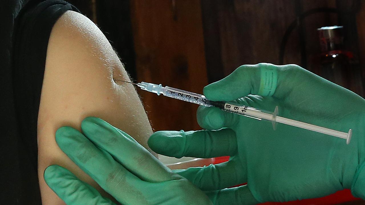Une jeune femme reçoit un vaccin contre le coronavirus. [Keystone/DPA - Wolfgang Kumm]