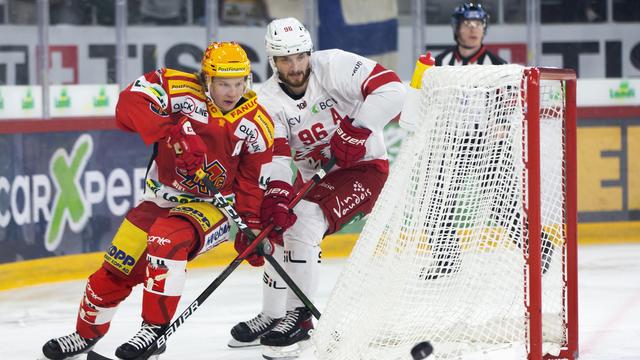 Duel entre le Biennois Toni Rajala (en rouge) et le Lausannois Andrea Glauser. [Keystone - Peter Klaunzer]