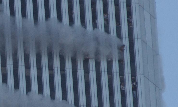 Des gens coincés dans les étages essaient de trouver de l'air aux fenêtres. [Keystone - AP Photo/Louis Lanzano]