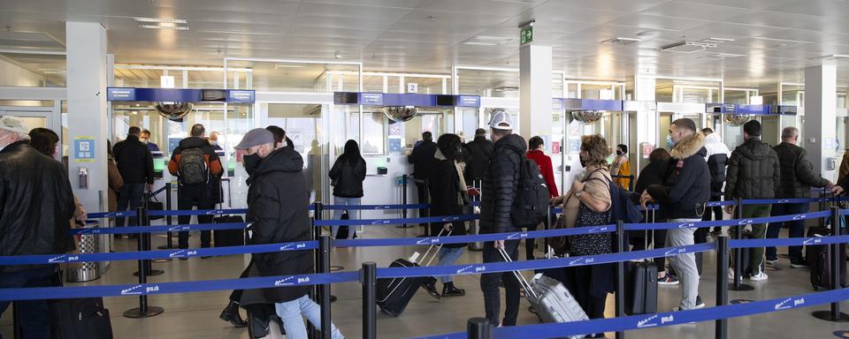 Des passagers masqués dans l'aéroport de Genève en février 2021. [Keystone - Salvatore Di Nolfi]