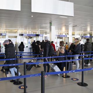 Des passagers masqués dans l'aéroport de Genève en février 2021. [Keystone - Salvatore Di Nolfi]