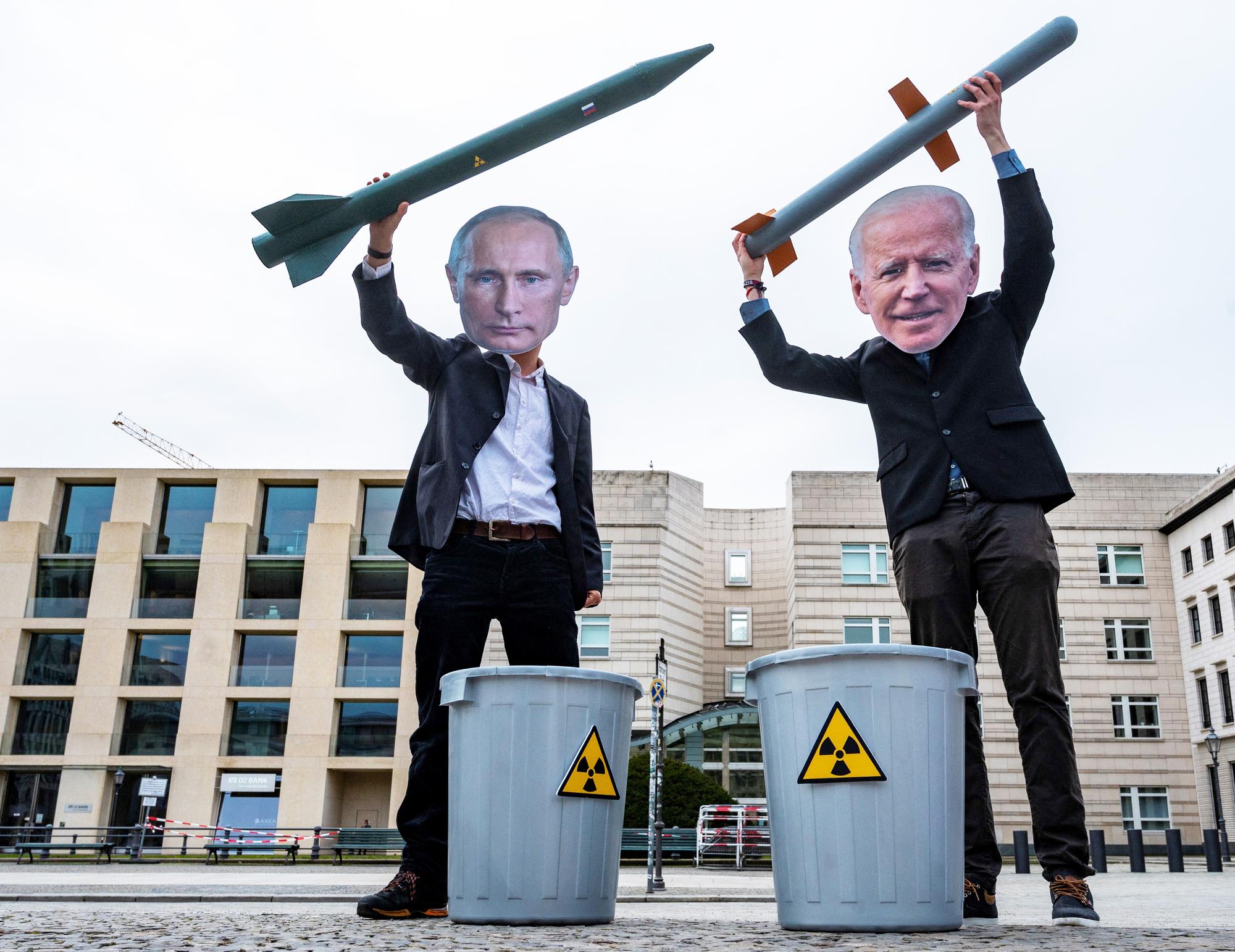 Des activistes portent des masques représentant les présidents russe Vladimir Poutine et américain Joe Biden, le 27 janvier 2021 lors d'une manifestation pour la paix à Berlin. [AFP - John MacDougall]