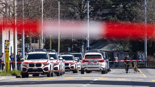 Des policiers patrouillent autour du gymnase de Beaulieu après une alerte à la bombe le mercredi 24 mars 2021 a Lausanne. [Keystone - Jean-Christophe Bott]