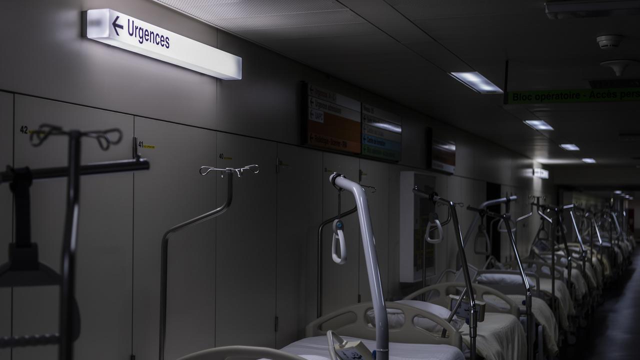 Des lits sont préparés dans le couloir adjacent à l'unité de soins intensifs, durant la pandémie de coronavirus, au CHUV. Lausanne, le 6 novembre 2020. [Keystone - Jean-Christophe Bott]