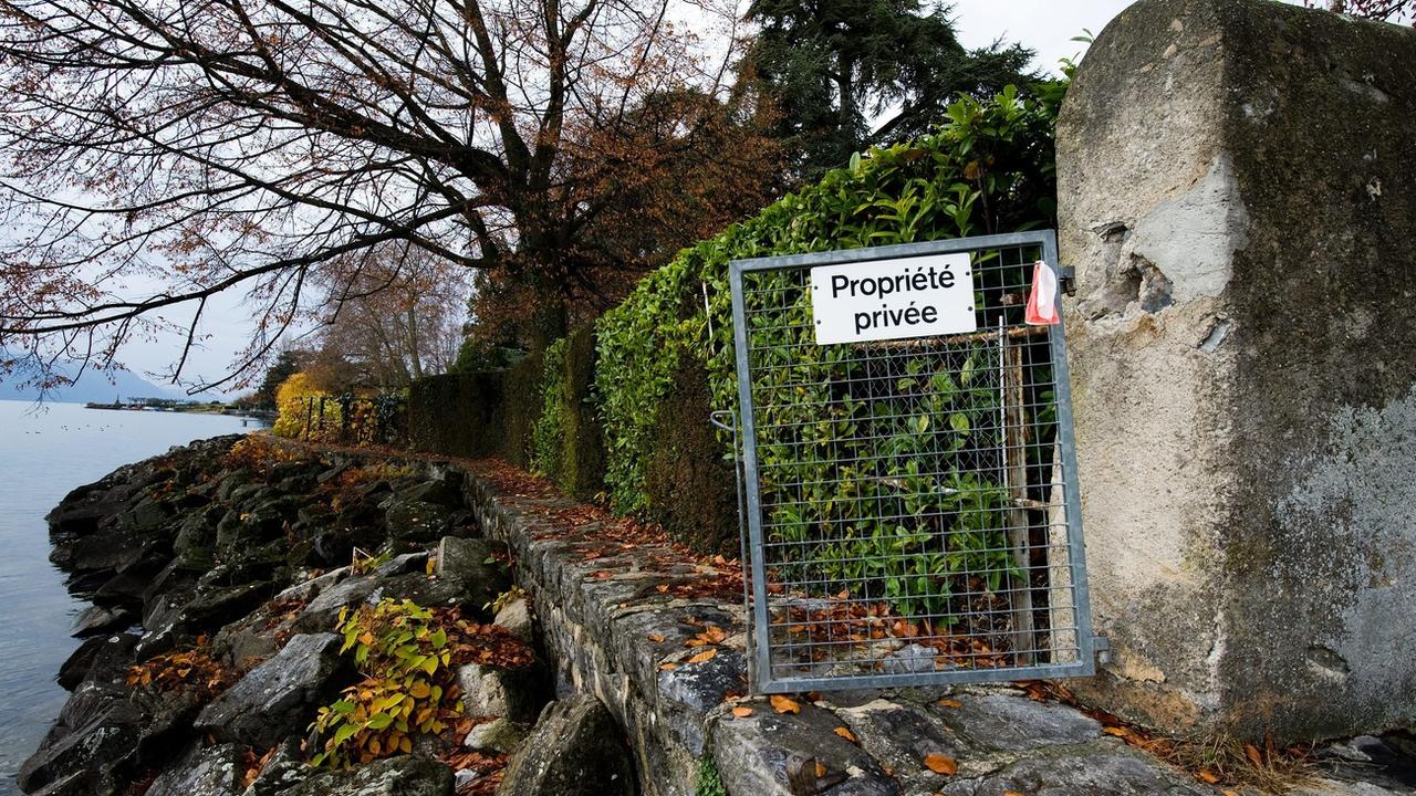 Une barrière sur laquelle est écrit "propriété privée" annonce l'interdiction de passage le long du bord du Lac Leman.