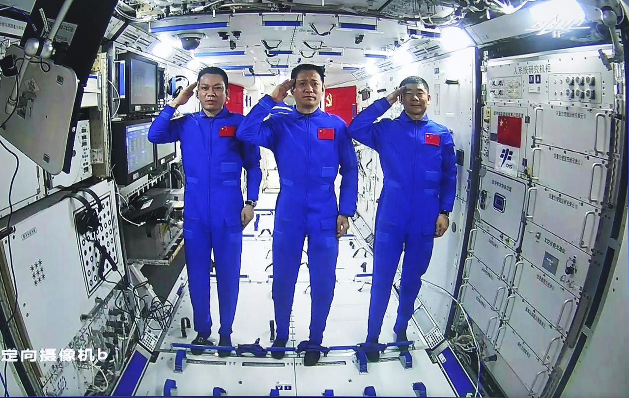 De gauche à droite, les trois taïkonautes à bord du module central de la station spatiale Tianhe: Tang Hongbo, Nie Haisheng et Liu Boming, le 4 juillet 2021. [Keystone - Yue Yuewei/Xinhua via AP]