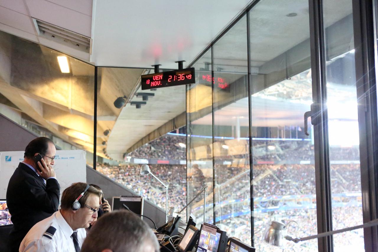 Le président François Hollande avec la sécurité du Stade de France, au moment d'être informé que plusieurs attaques terroristes ont frappé Paris. [Présidence de la République/AFP - Christelle Alix]